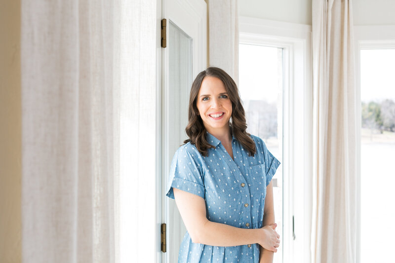 Amanda smiling in a blue and white polka dot dress