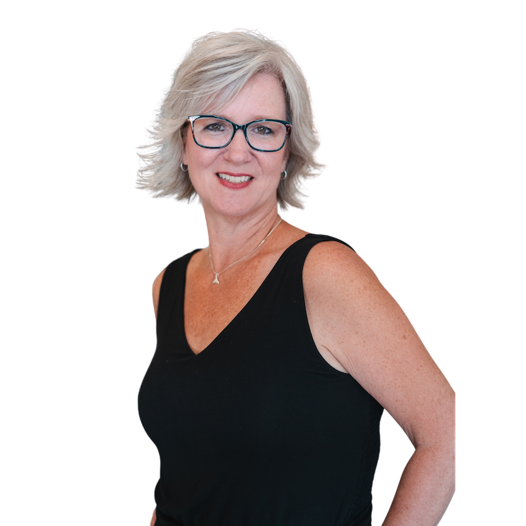image of Jennifer, owner of Jenny Laine Designs. She is light skinned with short, light hair. She is wearing a black tank top and green framed glasses. She is sitting in front of a pink Apple laptop.
