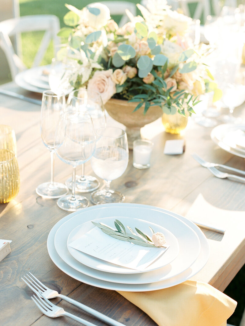 earth tone table setting with olive branch and peach flowers at outdoor reception in santa ynez, ca