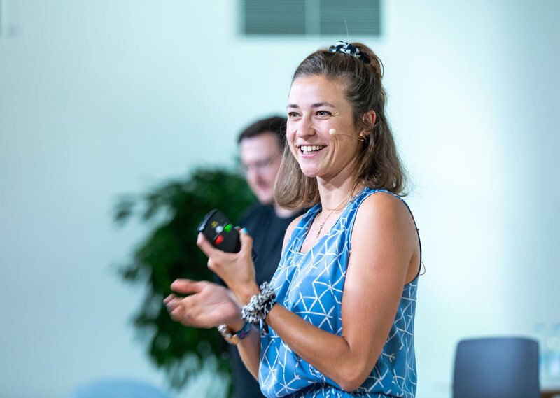 Moderatorin Hanna Zöller auf Bühne in München, lächelnd bei Eventmoderation mit Headset-Mikrofon – persönliche Vorstellung