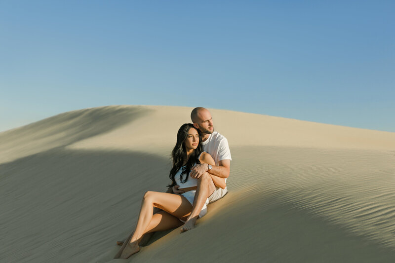 engagement photos with couple walking on sand