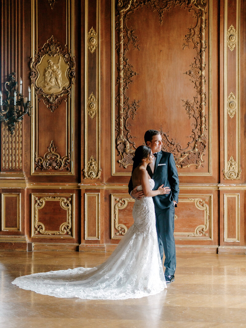 Bride and groom looking off camera right inside a ballroom