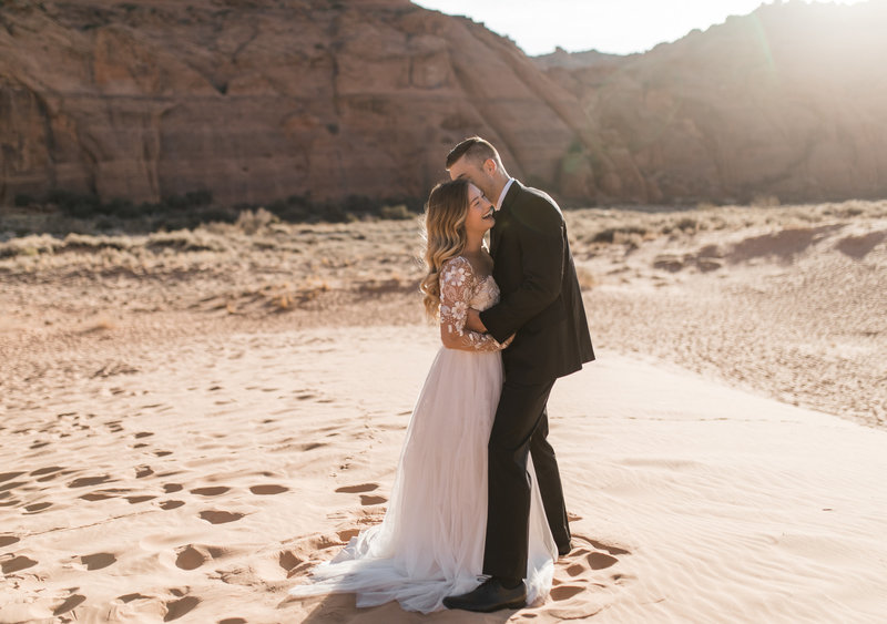 bride and groom hugging in desert