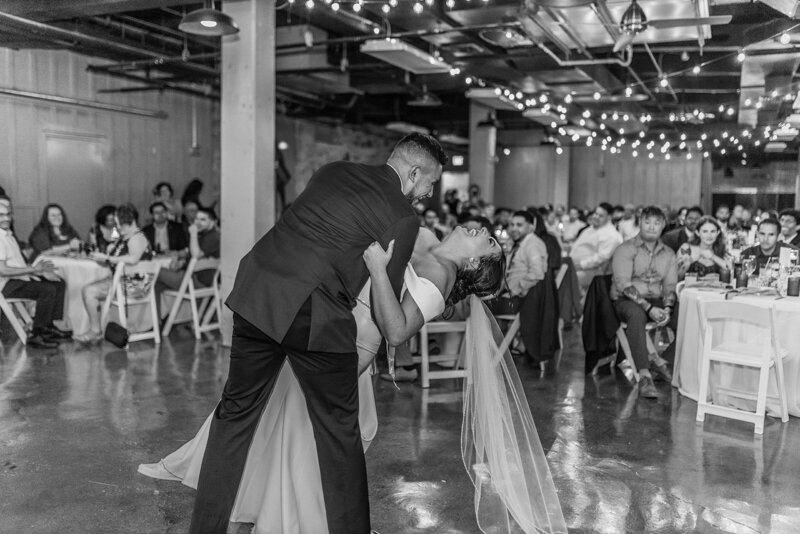 Bride and groom happily dancing in a black and white photo on their wedding reception