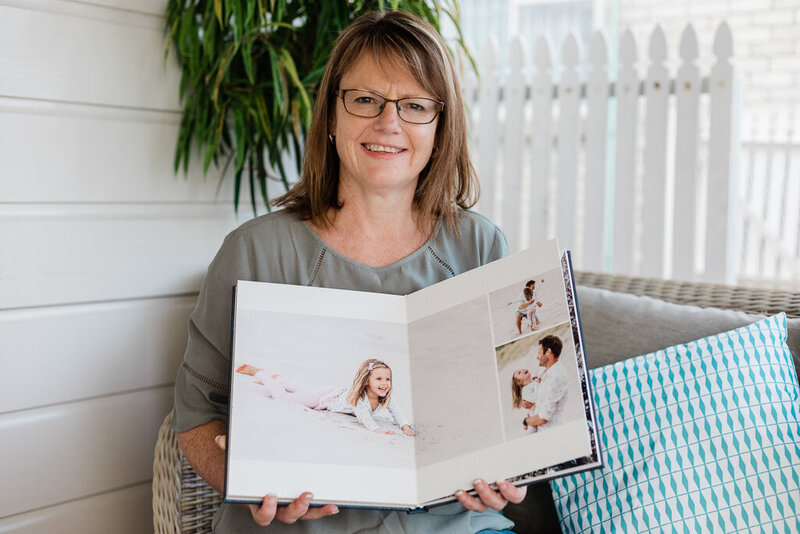 Whangarei Photographer Tracey Morris holding  family album which are a specialty for her business