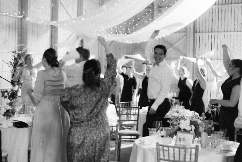 Guests welcoming the cake at the wedding in an image photographed by wedding photographer Hannika Gabrielsson.