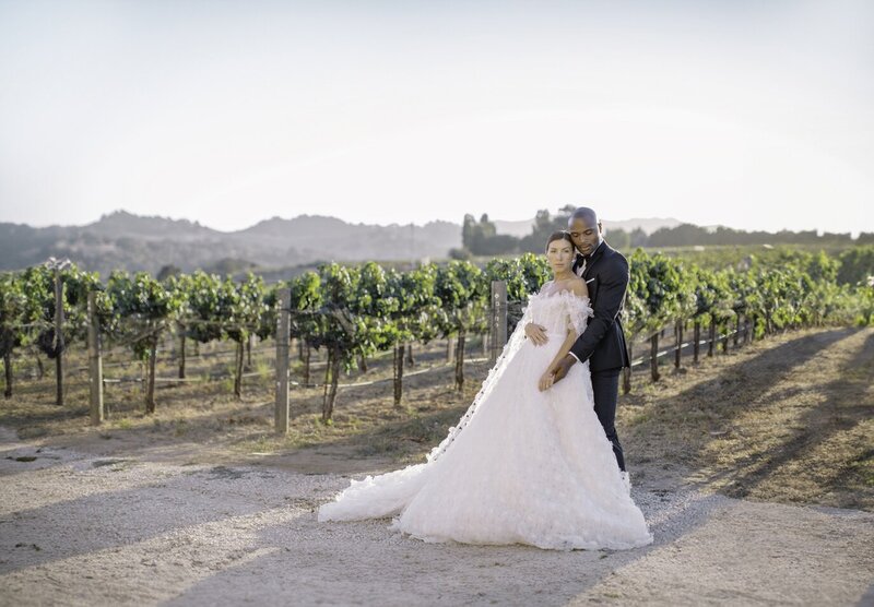 bride and groom in front of vineyard at sunstone winery wedding