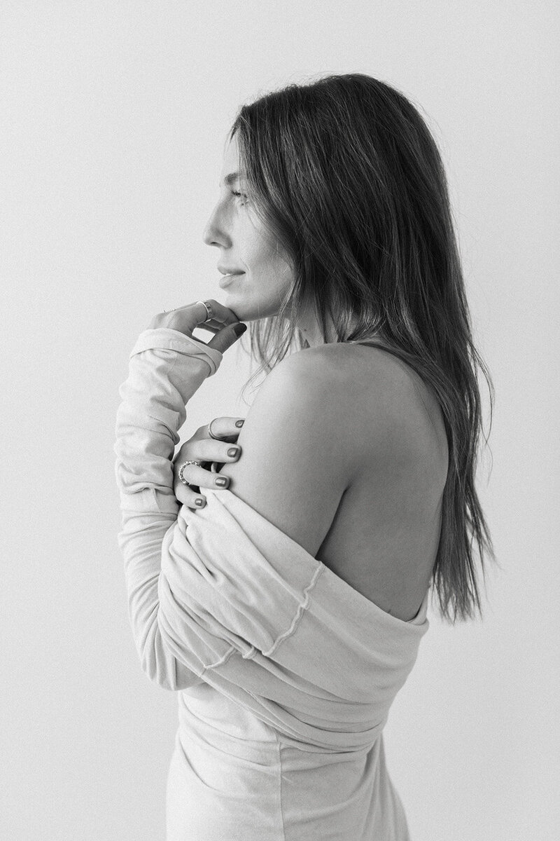 A collage of photos of a woman wearing a black top and jeans with sweater off her shoulders.