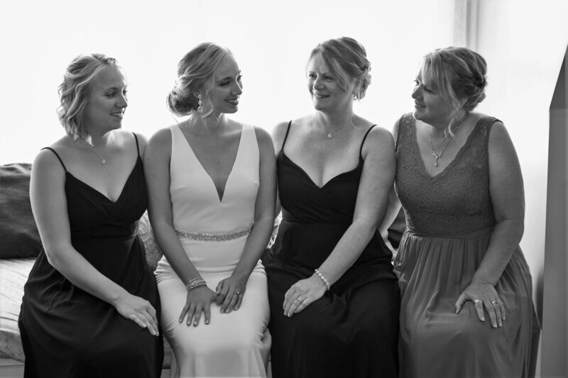 Bride sitting with a few bridesmaids | Klein Wedding at Grace on the Lake