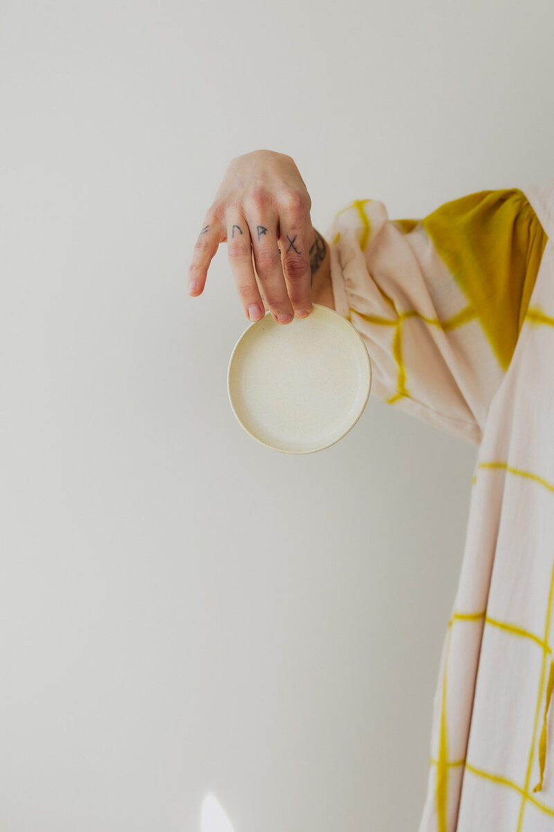an artist holding their pottery