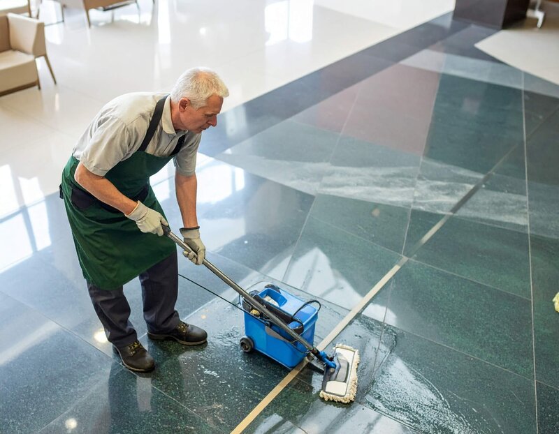 professional cleaning woman, vacuuming the carpet in a trendy commercial office space