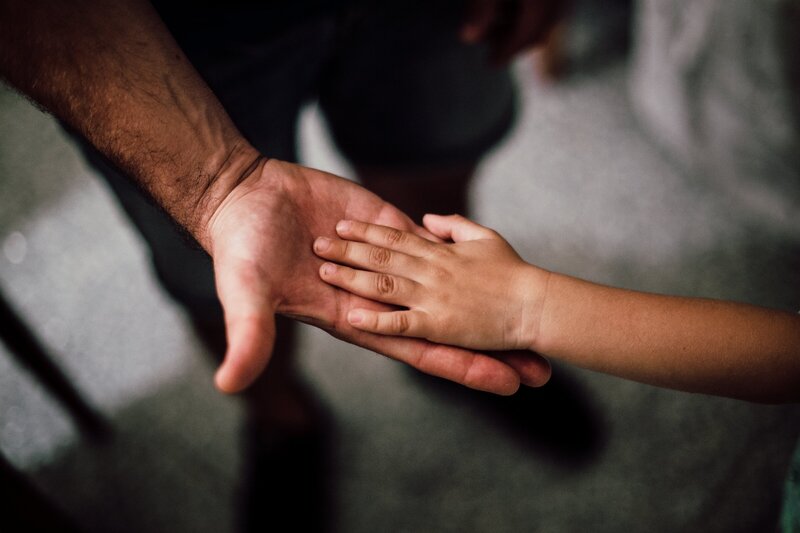 Une femme assise qui  tient sa tête entre ses mains