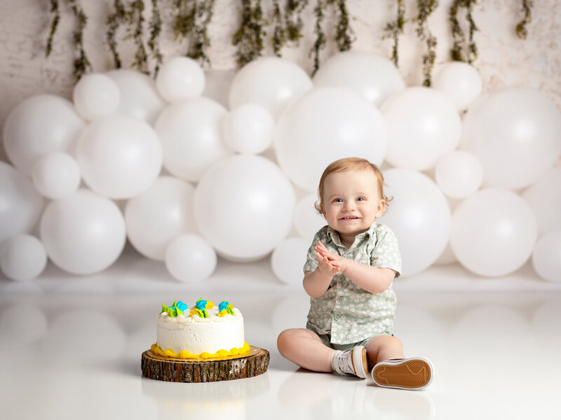 one year old sitting next to cake for first birthday cake smash Cleveland family photographer
