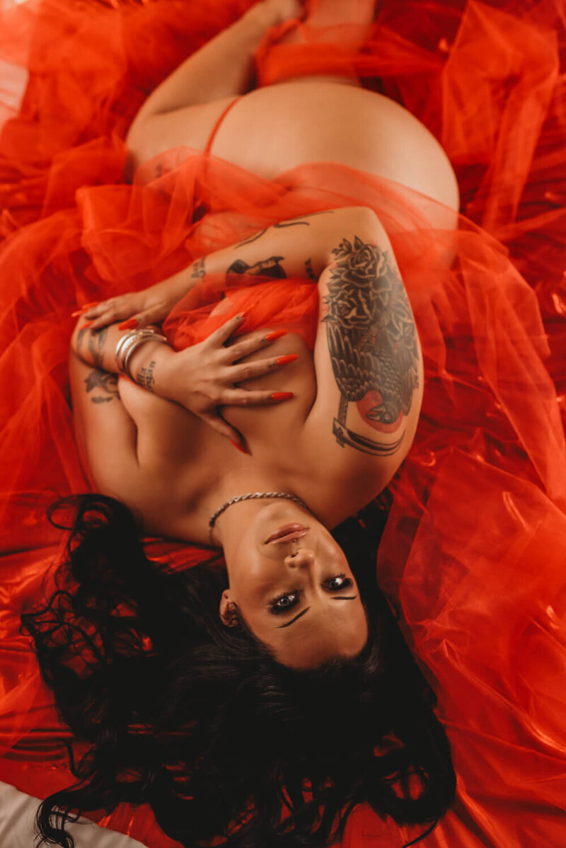 Woman in red chiffon fabric during boudoir photoshoot
