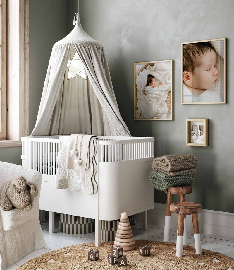 Interiør til et babyrom med rammete veggbilder fra nyfødtfotografering som henger på veggen.