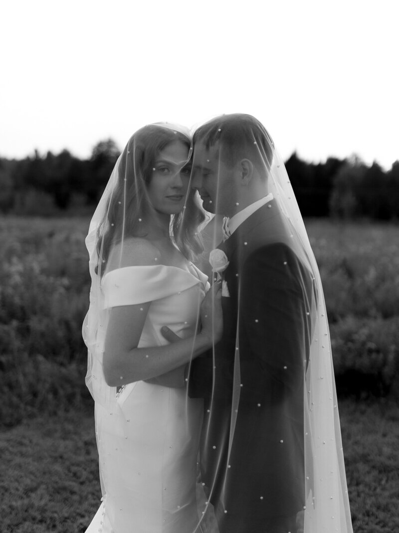 VT Wedding Photographer | Sincerely Liz Photography Documentary Wedding, Engagement, Elopement, Maternity and Newborn Photographer in New England | Bride and groom embrace under a veil in an outdoor New England Wedding venue