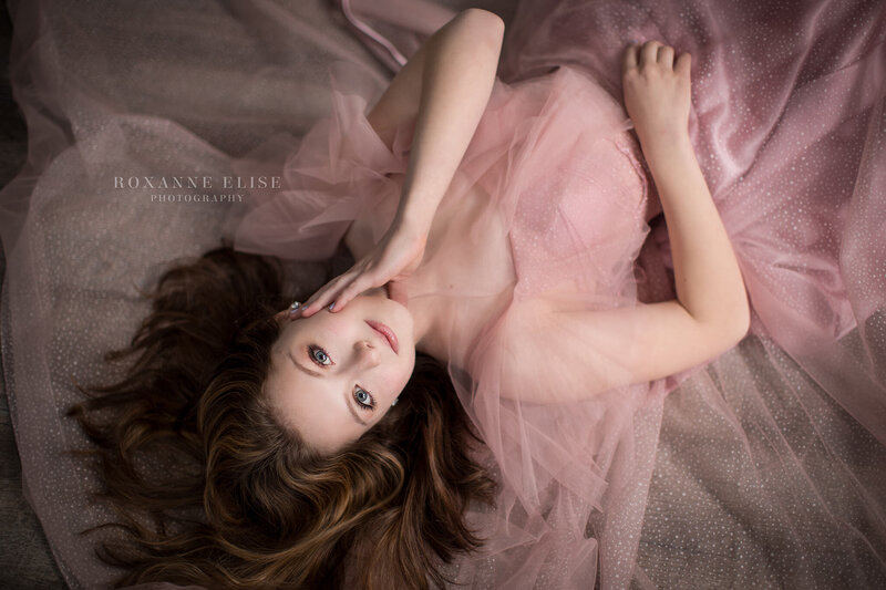 teen girl lying down wearing pink dress