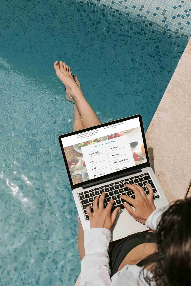 A woman relaxes in a pool with her laptop, enjoying a sunny day while working on Zoe Schroeder Nutrition.