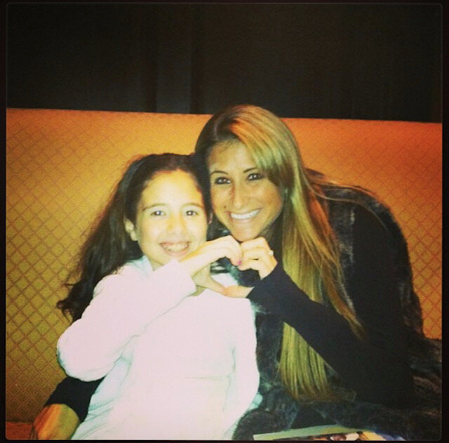 Child and therapist making a heart shape with their hands
