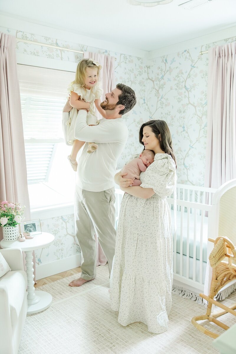 newborn session with toddler sibling sister and baby girl in nursery with family