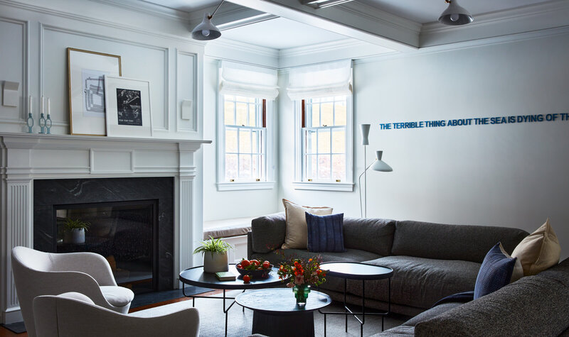 Boston interior decorator designs a modern family room in a historic Concord home, blending contemporary art with traditional architectural details.