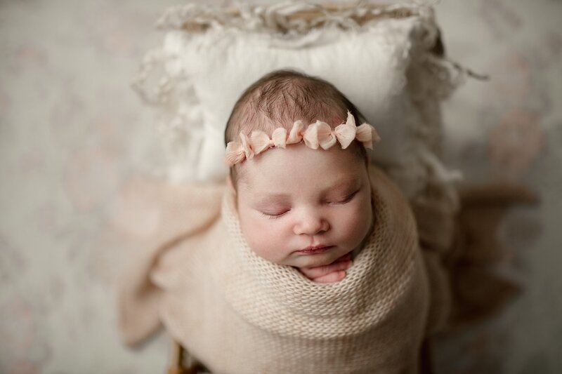 sleeping-newborn-girl-swadled-in-pastel-blankets