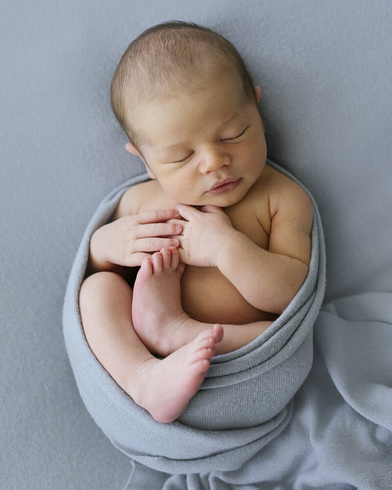 newborn baby boy, swaddled in luxury blue fabric all squished up, Perth newborn in home session