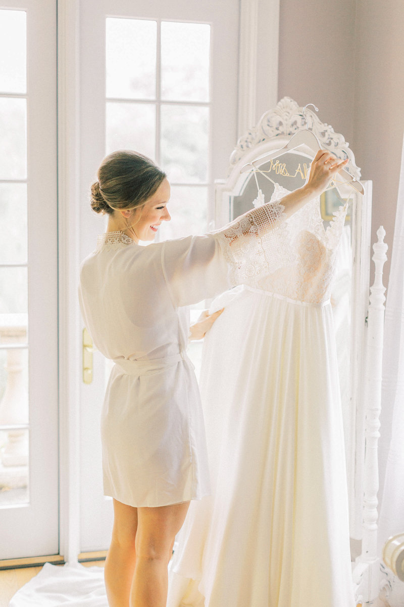 beautiful bride admires her custom made wedding gown in the bridal suite at historic acres of hershey