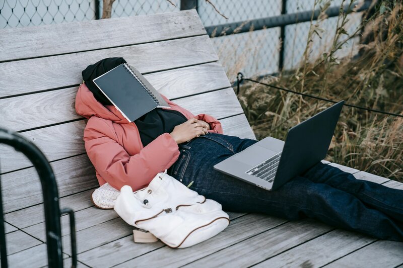 Student avoiding work with a book over her face