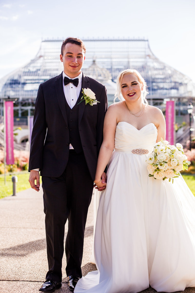 Bride and groom pose outside the Phipps Conservatory