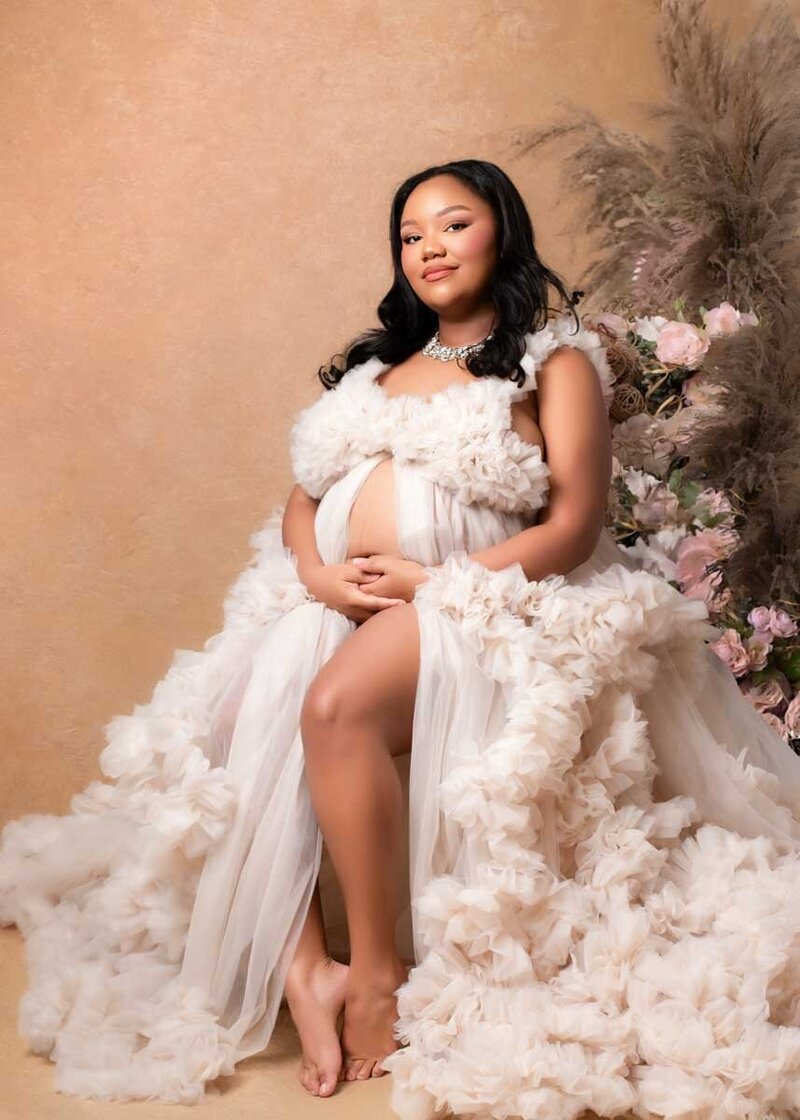 Birmingham maternity photographer captures pregnant mother in a flowing cream studio gown.