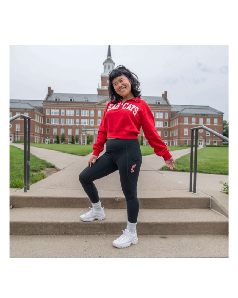 Model wearing red Bear Cats half zip pullover outdoors