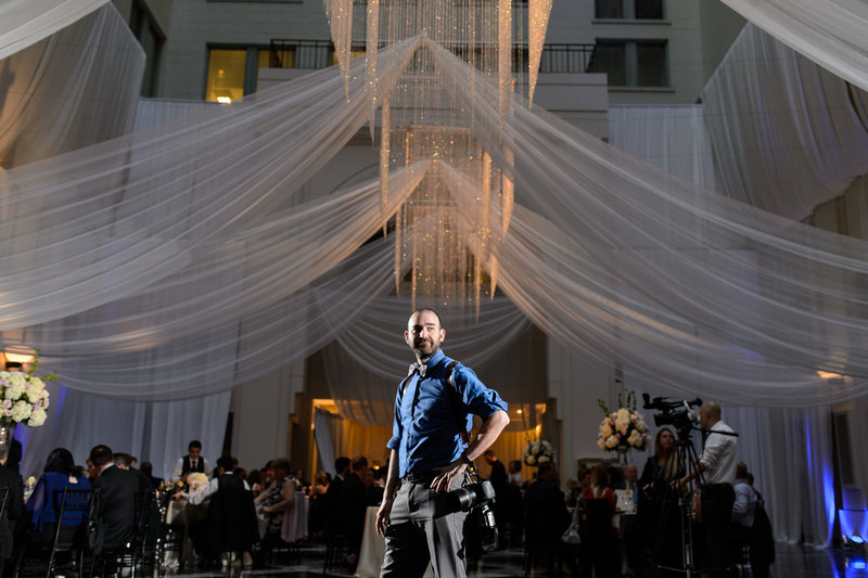 A wedding photographer working at a reception at the curtis center in philadelphia.