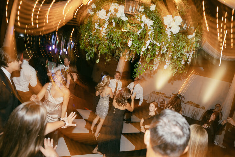 A fun, light blurring photo of the dance floor at Grand Geneva Resort Chalet featuring a checkered dance floor.