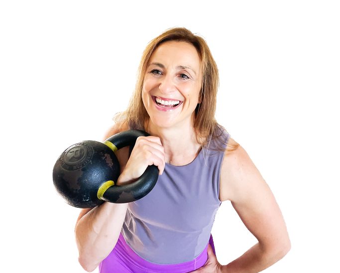 Vanessa, a midlife strength coach, smiling confidently as she holds a kettlebell in the rack position on her shoulder, wearing a lavender tank top.