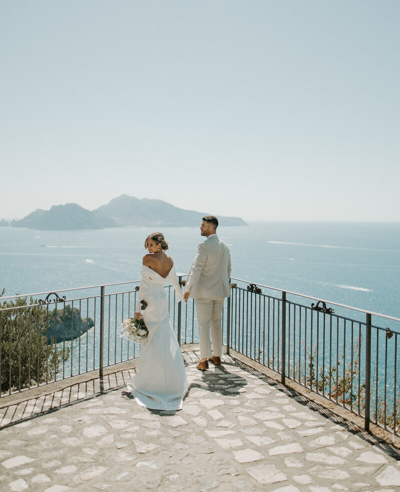 A couple stand on an overlook spot in the Amalfi Coast