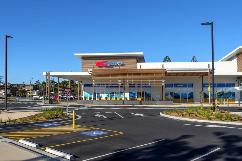 Marina Shopping Centre in Port Macquarie featuring Kmart signage, open car park, and timber-clad retail facade.