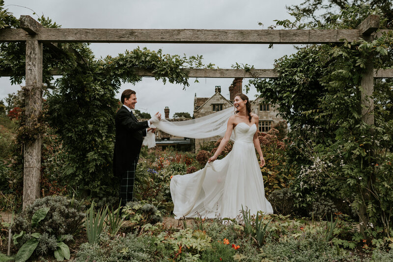 Bride Showing groom veil in garden