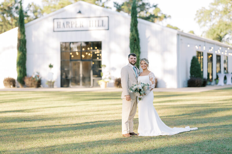 bride and groom posing in front of a venue building at Harper Hill Plantation