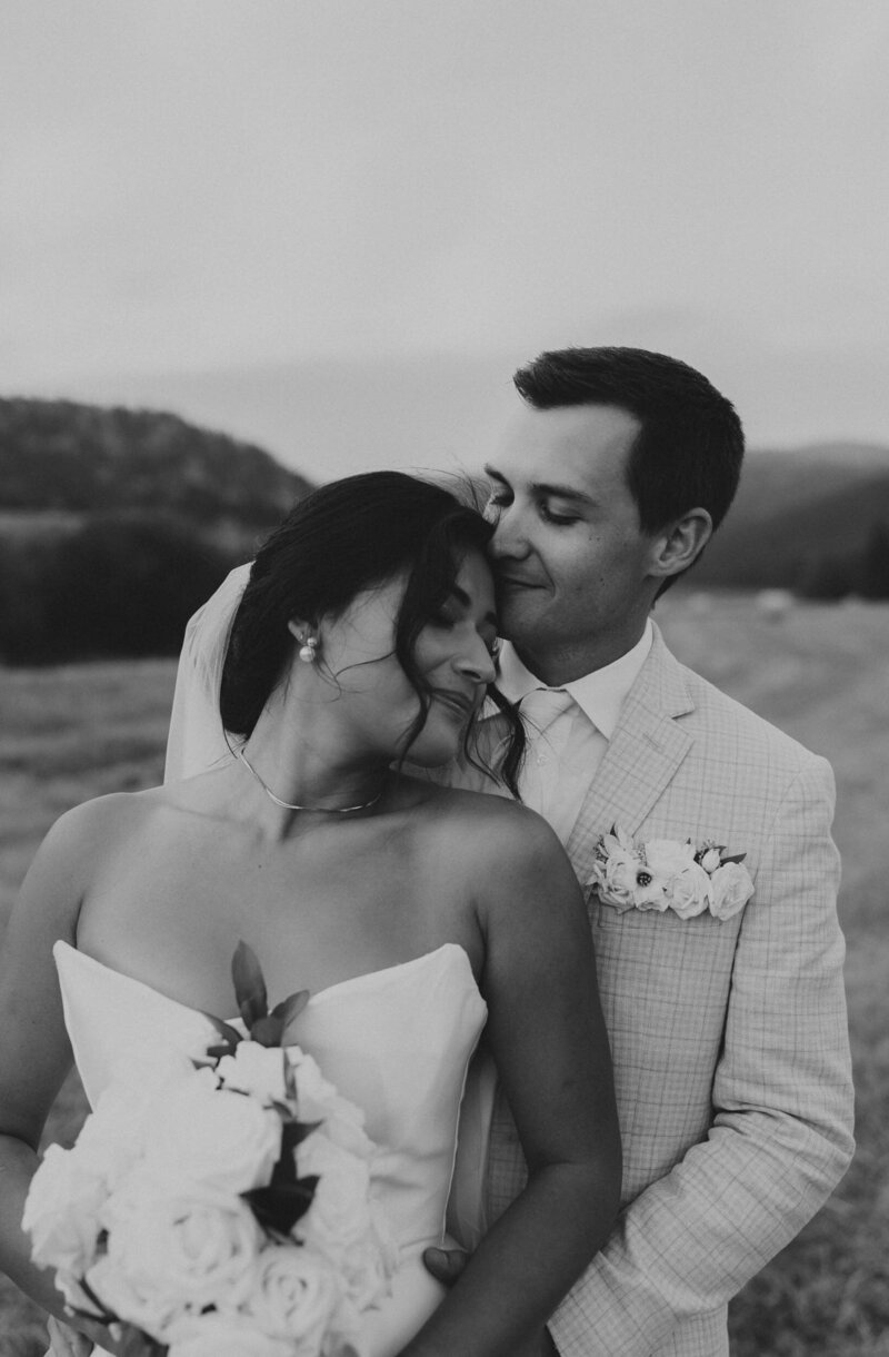 Couple holding each other with mountains in the background - Bozeman, Montana