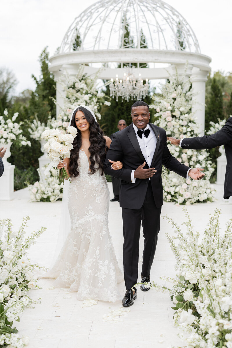 Bride and groom pose at outdoor wedding ceremony in CA.