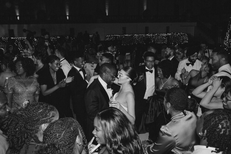 Bride and Groom dancing with wedding party at evening celebration