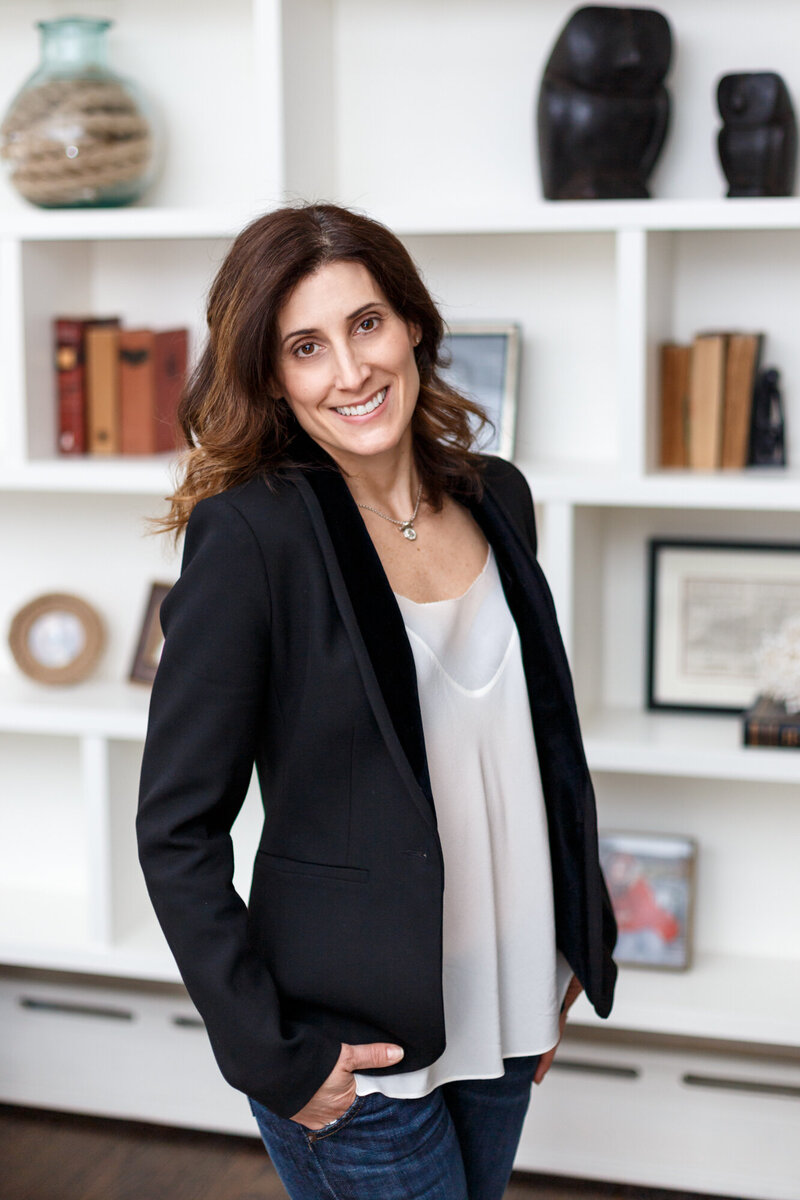 Interior designer in Illinois Deborah Silver posing with bookcase