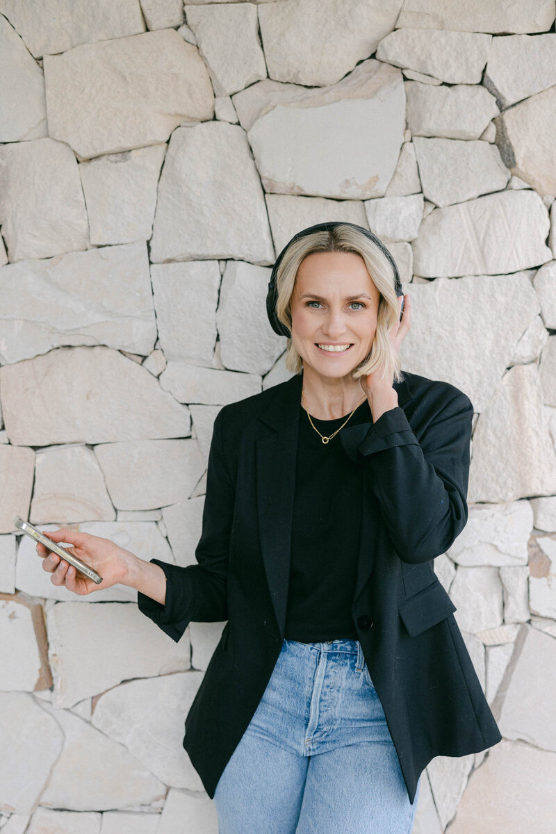 Zelda Green, smiling at camera while listening to the Good with Money podcast