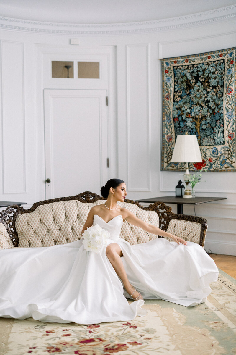Editorial bride portrait with bouquet moving her dress