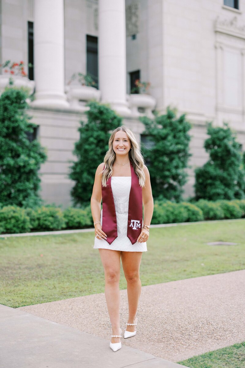 Senior walking in front of the Administration building of A&M