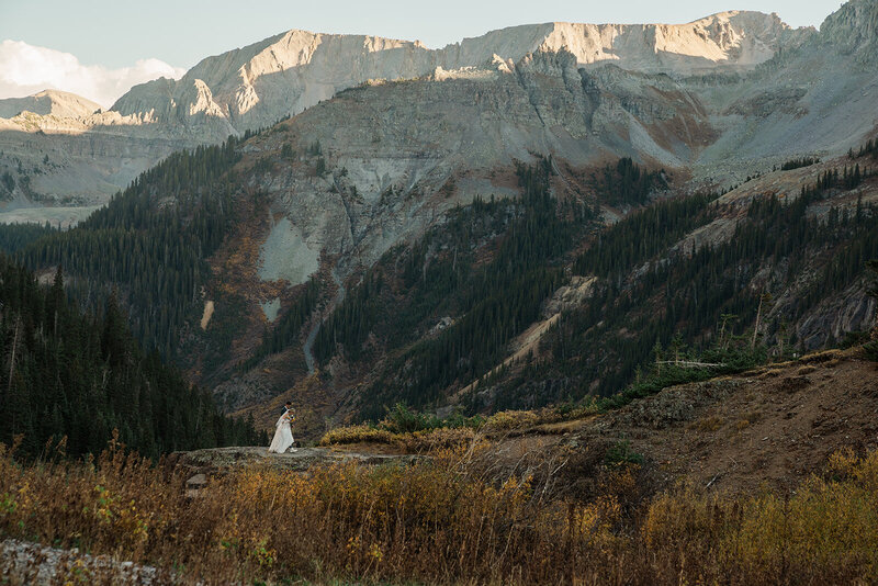 A bride and groom laugh together in golden light on a mountain in Silverthorne