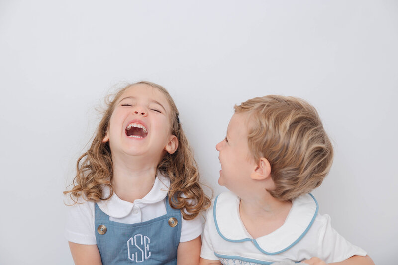 Brother and sister laughing during a family photoshoot at Heather Nicole Photography Studio in Redondo Beach, California.