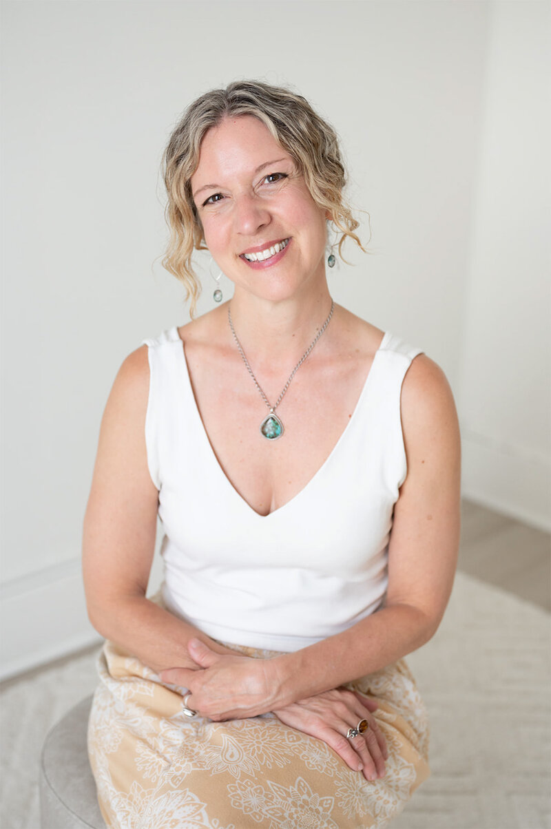 A woman wearing a white top and a gold necklace, featured in the Heidi Writer Bio section.