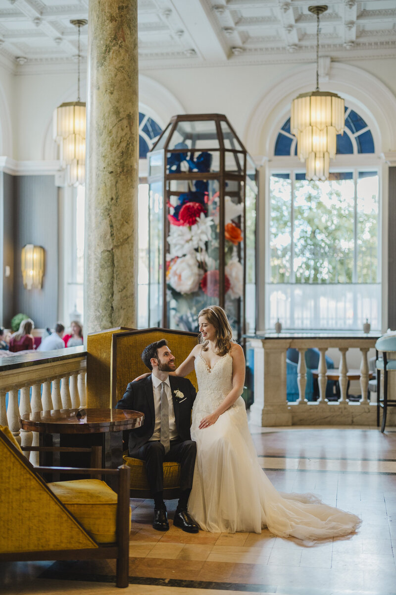 A couple sits at a chair in conversation at The Riggs Hotel.